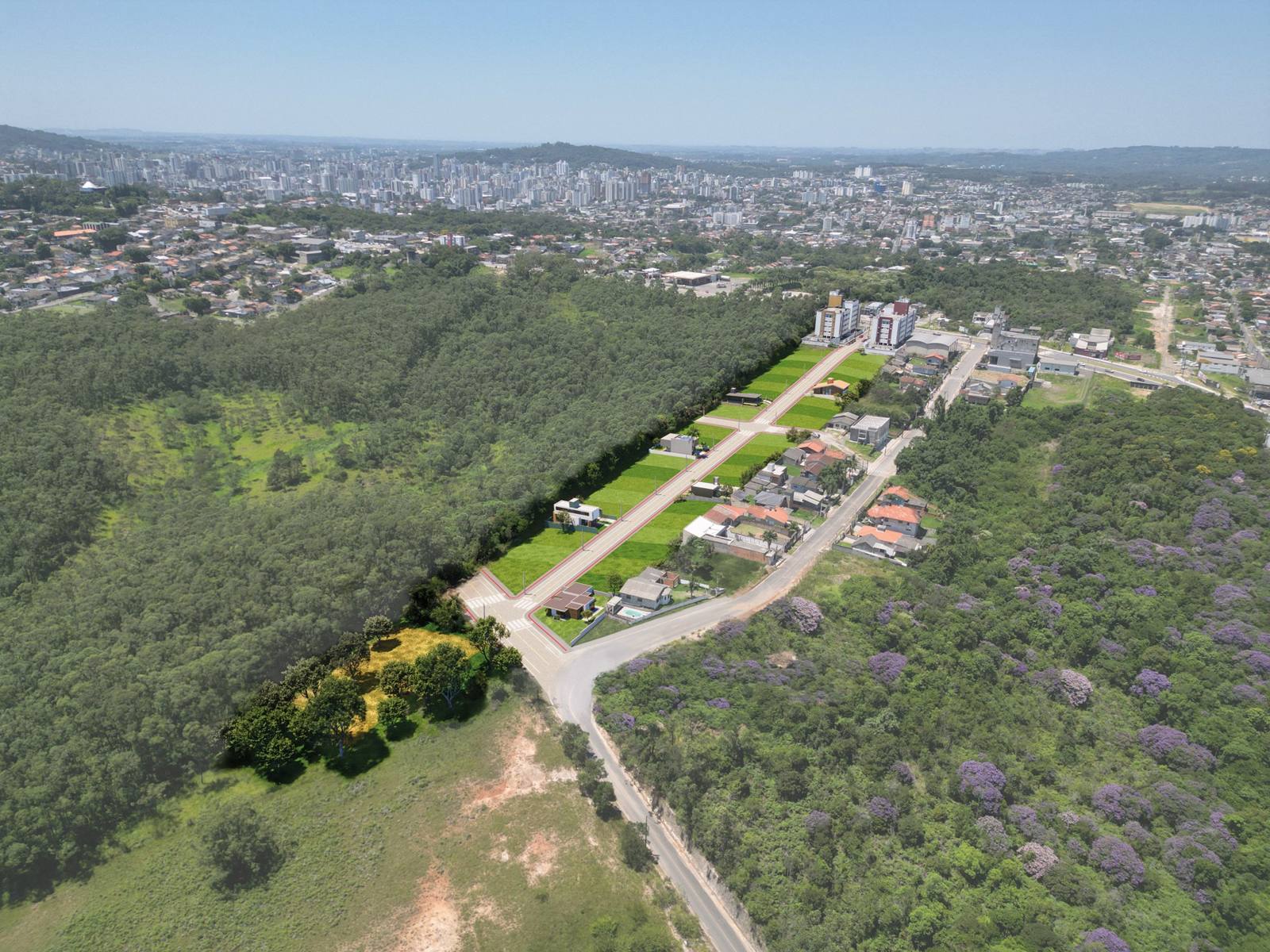 Vista aérea de um bairro de Criciúma, com a cidade ao fundo