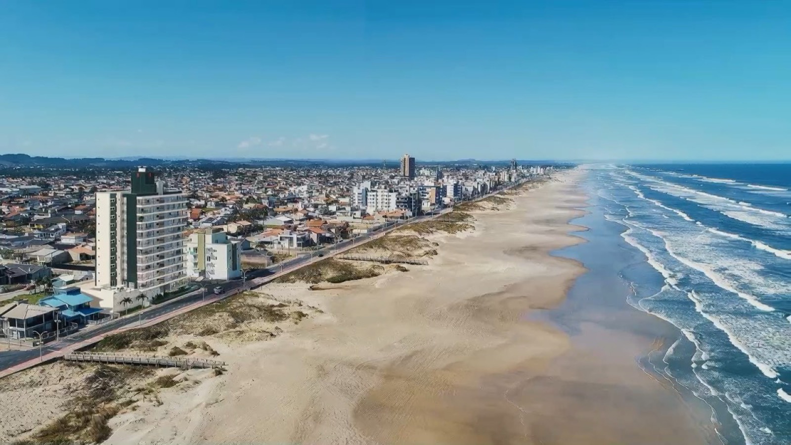 Vista aérea da orla do Balneário Rincão, com a praia e os prédios da avenida beira-mar